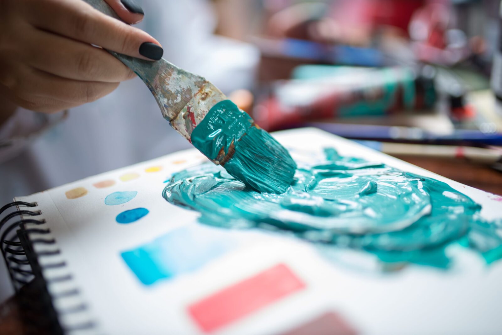 Artistic close-up of a paintbrush blending vibrant colors on canvas with a focus on creativity and expression.